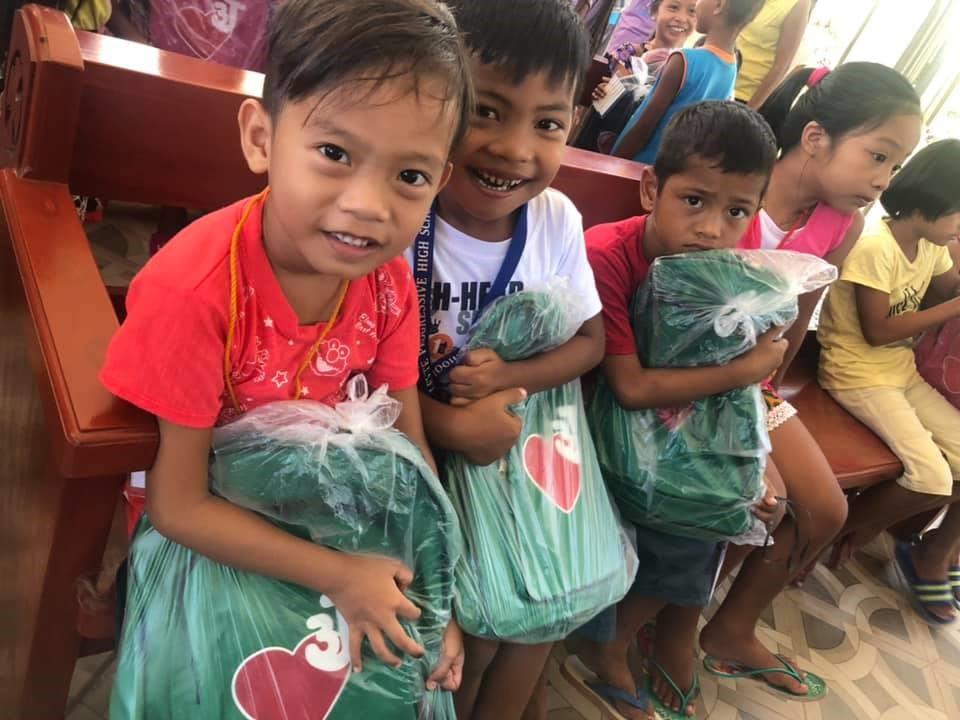 Grade school children receiving school supplies from outreach program